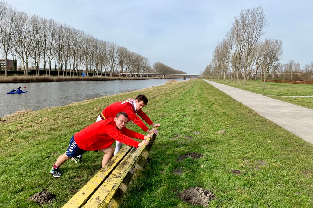 Sander en Marc stretchen voor hardlopen langs het kanaal.